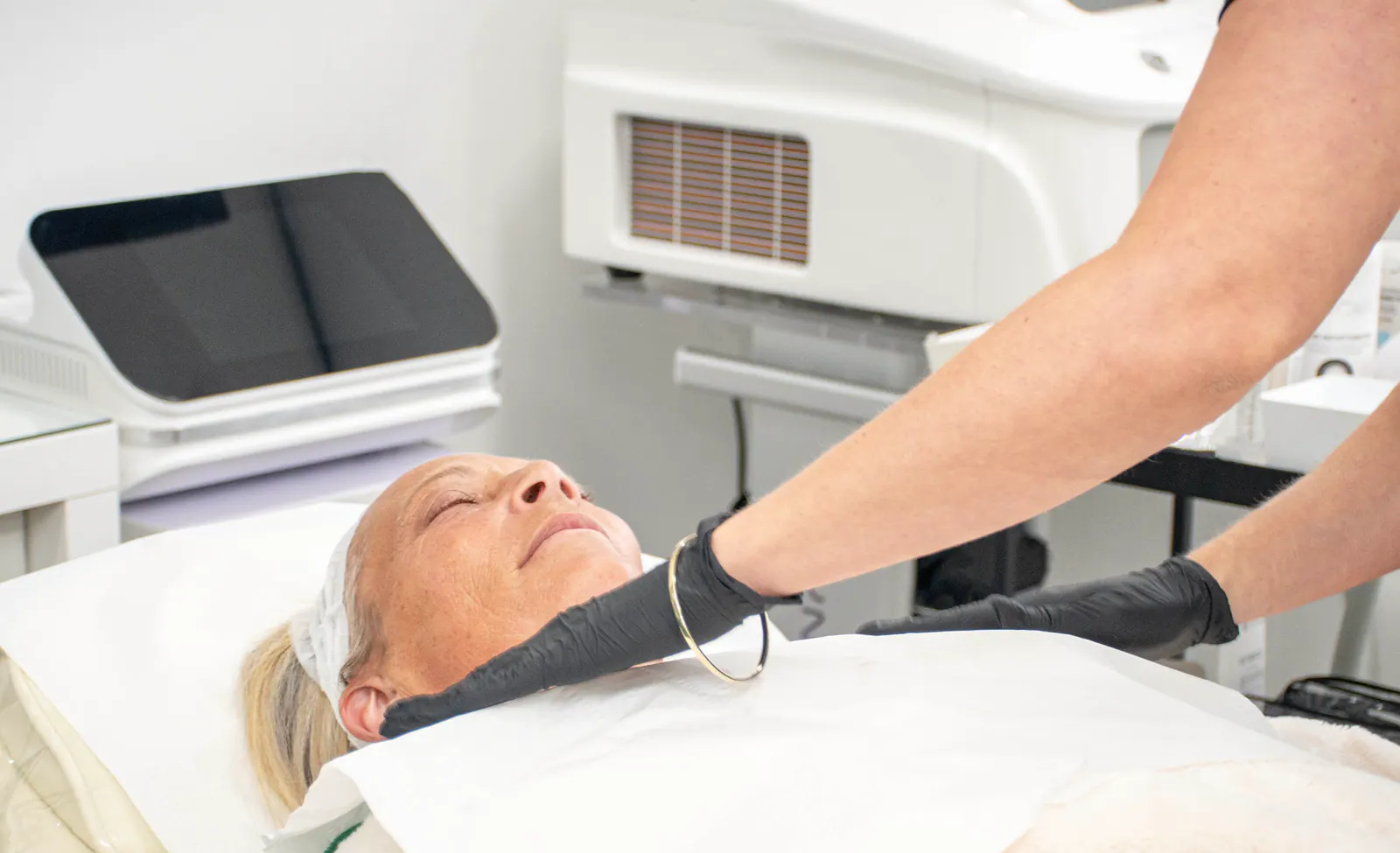 A treatment device being applied around the face and neck in the clinic.